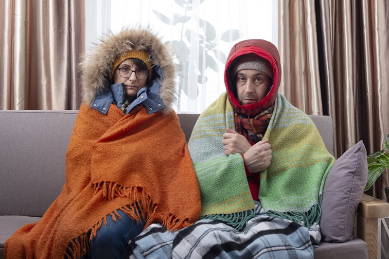 Family shivering indoors from lack of even heating.