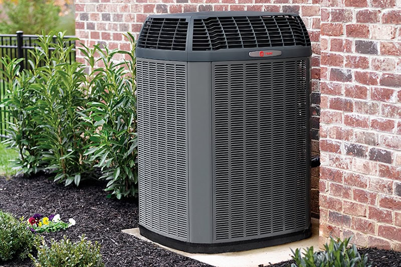 full shot of an air conditioner unit outside of a home.